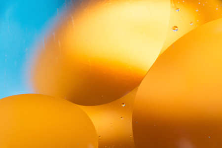 mixing water and oil, beautiful color abstract background based on blue and orange circles and ovals, macro abstractionの写真素材