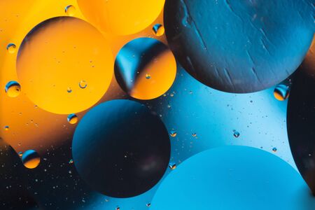 mixing water and oil, beautiful color abstract background based on blue and orange circles and...