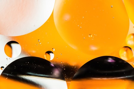 mixing water and oil, beautiful color abstract background based on yellow and black circles and ovals, macro abstractionの写真素材