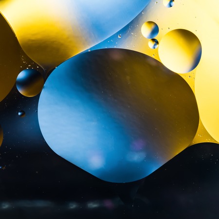 mixing water and oil, beautiful color abstract background based on yellow and blue circles and ovals, macro abstractionの写真素材