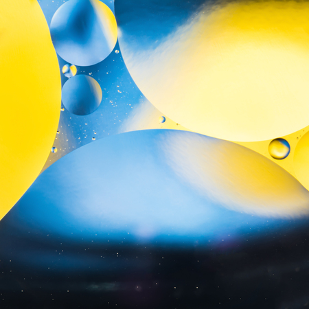 mixing water and oil, beautiful color abstract background based on yellow and blue circles and ovals, macro abstractionの写真素材