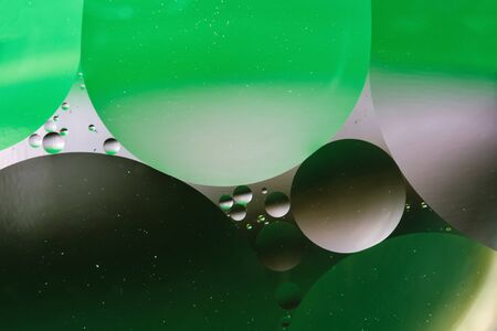 mixing water and oil, beautiful color abstract background based on green circles and ovals, macro abstractionの写真素材