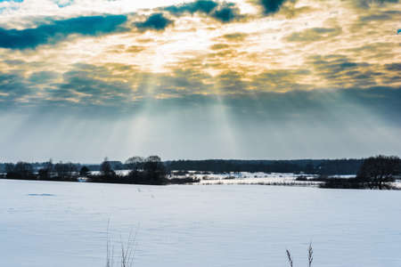 winter landscape, the rays of the sun make their way through thick clouds, nature backgroundの写真素材