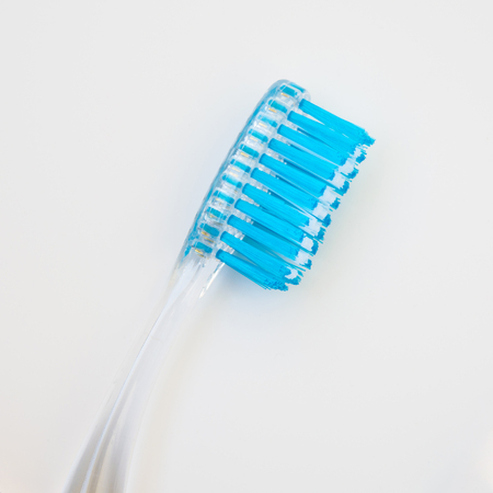 white blue toothbrush is located vertically with a slope on a white background, copy space, close-up...