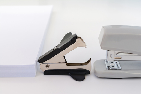 pile of white office paper, black staple remover and gray stapler on white background, concept abstract backgroundの写真素材