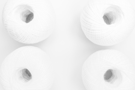 four skeins of white thread on white background, close-up abstract backgroundの写真素材