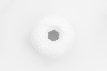 one skeins of white thread on white background, close-up abstract background