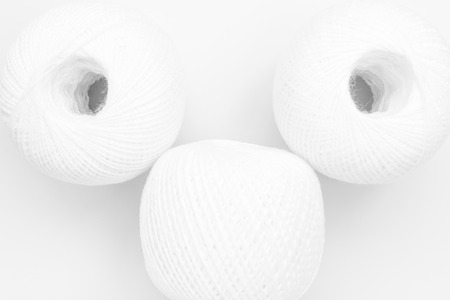 three skeins of white thread on white background, close-up abstract backgroundの写真素材
