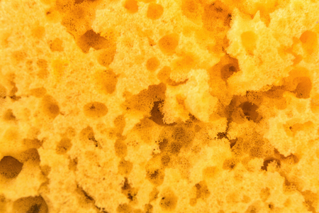 texture worn yellow sponge for washing dishes , close-up abstract background, selective focusの写真素材