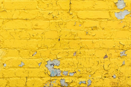 texture old brick wall painted yellow paint, peeling and crumbling paint on white bricks, architecture abstract backgroundの写真素材