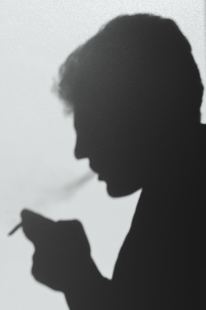 shadow of smoking man, young man smoking a cigarette, concept bad habit abstract background