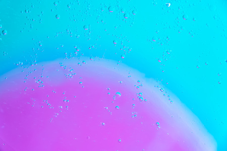 Water and oil bubble pink green background. Macro shot of beautiful water and oil bubble background , with small and big bubblesの写真素材