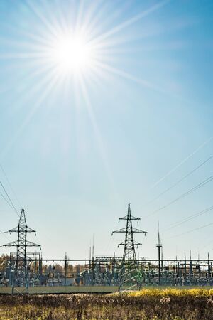 High voltage pole, High voltage power electric transformer substation, modern technology abstract background. Sunny autumn day with clear blue skyの写真素材