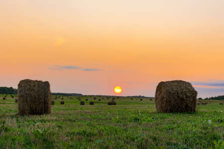 Two bales of straw on foreground on the autumn meadow during wonderful sunset light. Nature backgroundの写真素材