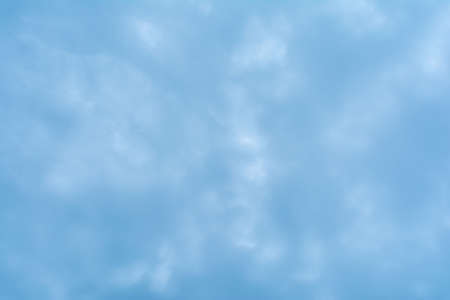 Abstract background based on clouds of uncertain shape in light blue sky. Blurry texture