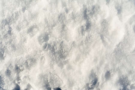 White uneven snow texture with embossed shadows. Abstract background with snowy surface in spring time.の写真素材