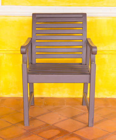 Wooden chair on yellow wall.の写真素材