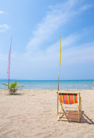 Beach chairs on the white sand beach with cloudy blue skyの写真素材