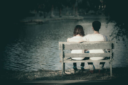 Couple relaxing along embrace the waterfrontの写真素材