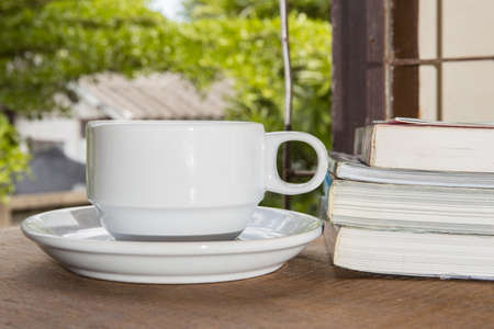 Cup of coffee, books, on tableの写真素材