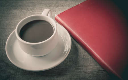 Cup of coffee, books, on table woodの写真素材