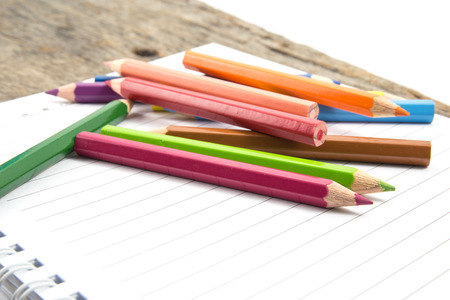 Blank paper and colorful pencils on the wooden table の写真素材