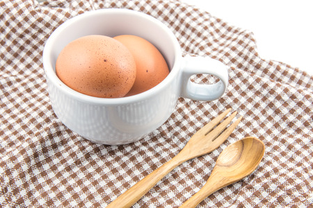 fresh eggs with cup and spoon wooden on tableの写真素材