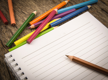 Blank paper and colorful pencils on the wooden table の写真素材