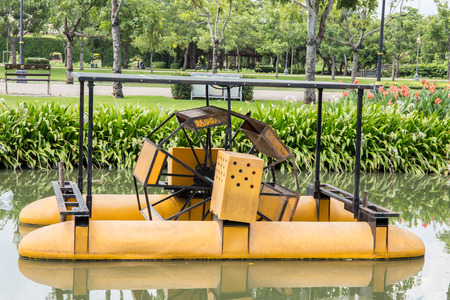 A water wheel floating on the canal of parkの写真素材