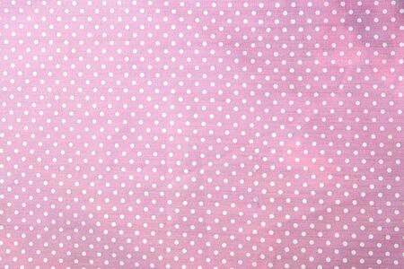 pink polka dot fabric closeup. May use as backgroundの写真素材