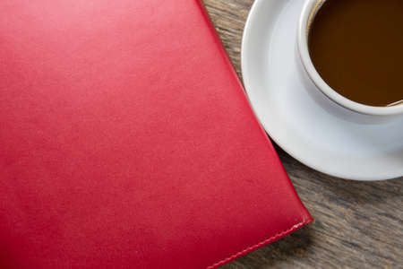 notebook and cup of coffee on the deskの写真素材