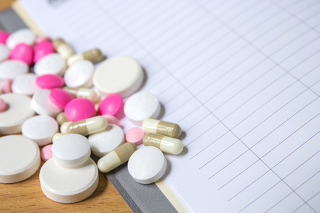 insulin syringe and colorful pill and capsules on wood backgroundの写真素材