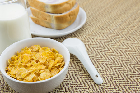 healthy breakfast: cornflakes with milk and breadの写真素材
