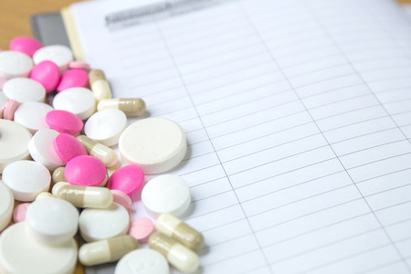 insulin syringe and colorful pill and capsules on wood backgroundの写真素材