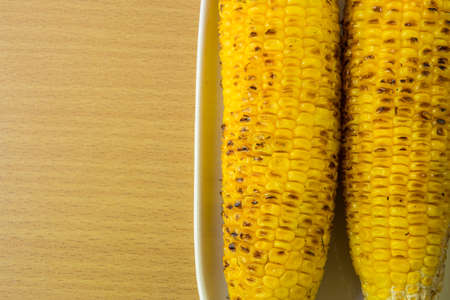fresh golden yellow corns on the cob roasted on a grillの写真素材