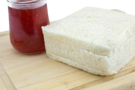 A bottle of strawberry jam and brea