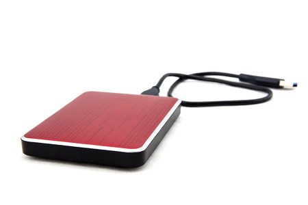 Red external hard drive with usb cable on the white background.の写真素材