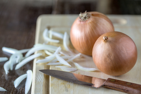 Fresh onions on a cutting boardの写真素材