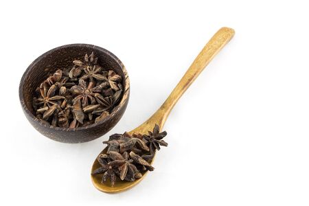 Star anise on wooden spoon and bowl on white backgroundの写真素材