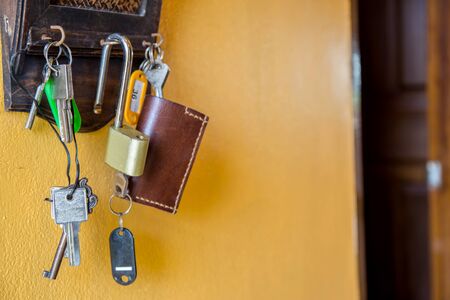 Door, house keys hanging on hooks on a wall.の写真素材