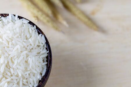 raw white rice in a bowl on wood table, top viewの写真素材