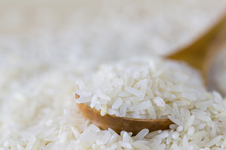 raw white rice in a wood spoonの写真素材