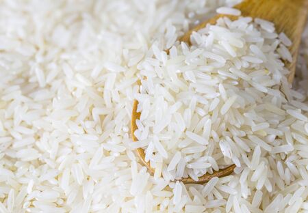raw white rice in a wood spoonの写真素材