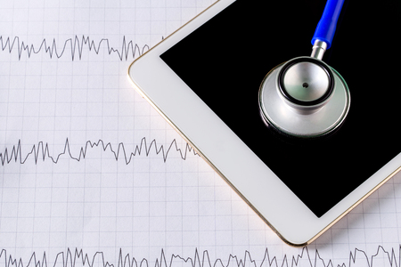 Medical equipment: blue stethoscope and tablet with graph.