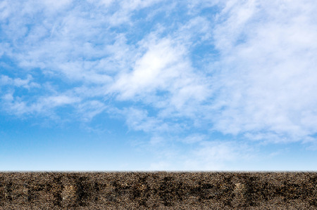 A field of soil on a background of blue sky.の写真素材