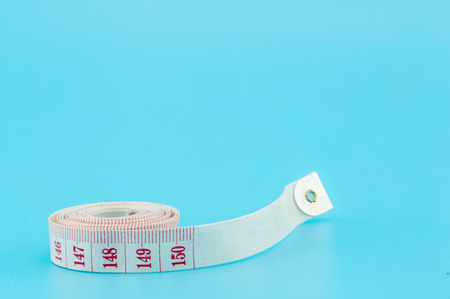 Tape-measure on a light blue background
