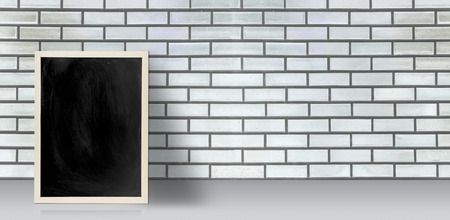 Blank chalkboard, blackboard on floor with white brick wall with copy space, Blackboard on a grunge wall for graphic apply work about business, education or otherの写真素材