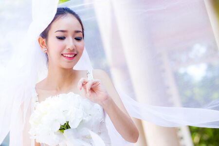 beautiful young woman on wedding day in white dress in the garden. Female portrait in the park.の写真素材