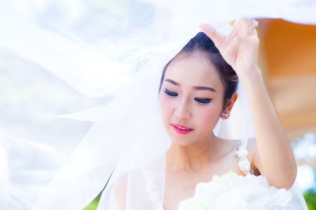 beautiful young woman on wedding day in white dress in the garden. Female portrait in the park.の写真素材