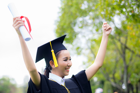 successful graduating student with nature background, Happy graduated student girl, congratulations, concept educationの写真素材